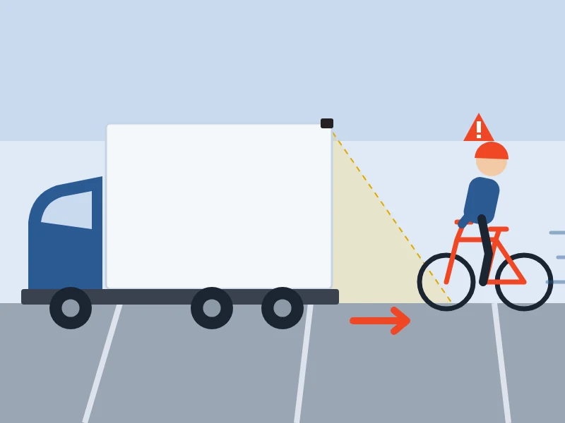後退するトラックの後方へ、カメラの範囲の外から自転車が近づくイラスト